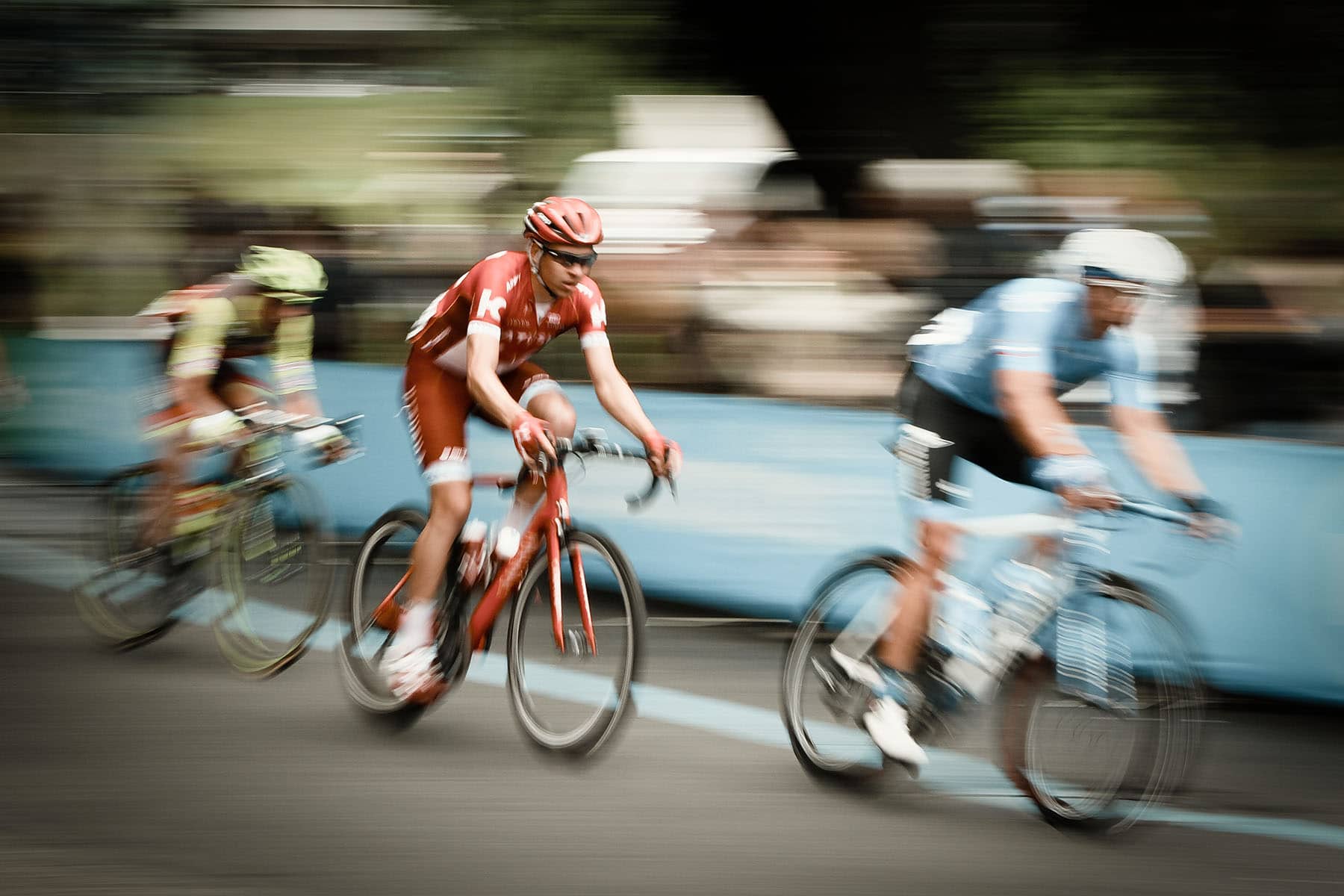 Three men racing on bicycles
